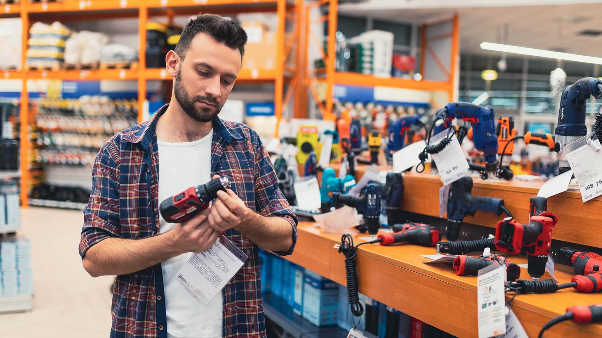 A man examines a power tool or drill at a big box hardware store unaware if it could be a defective product and finds himself in a product liability case
