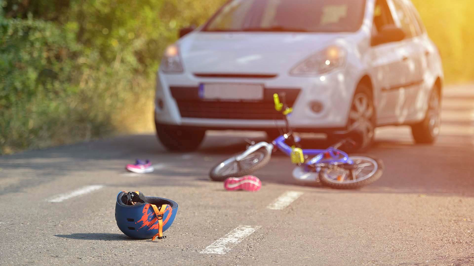 A bicycle and helmet laying on the road after rider was hit by a car