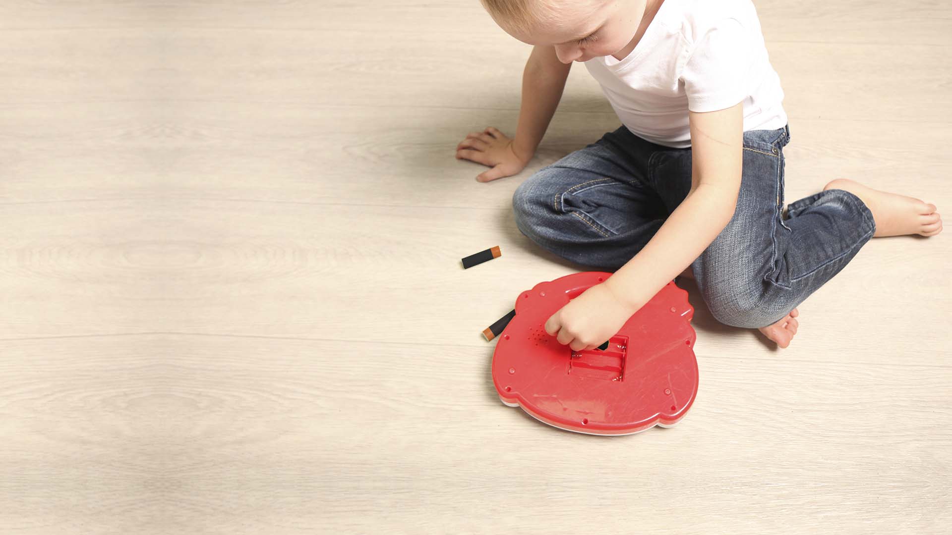 Child playing with a potentially dangerous and defective toy with access to batteries