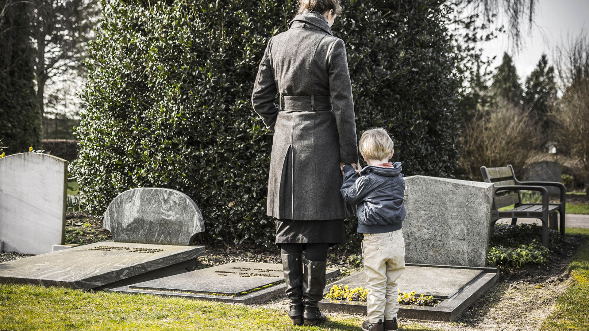 A mother and son in a cemetery viewing the grave of man who suffered a wrongful death